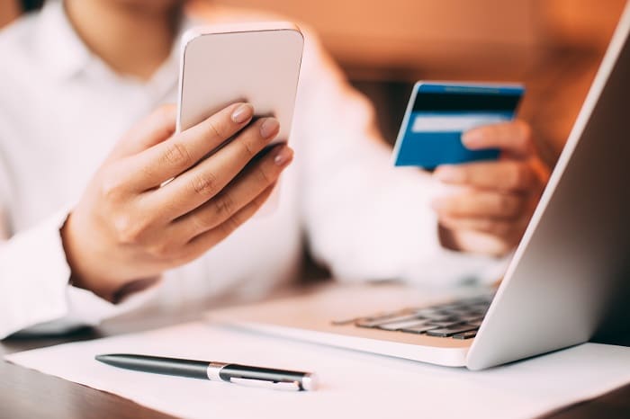 Female hand holding smartphone and credit card compra online