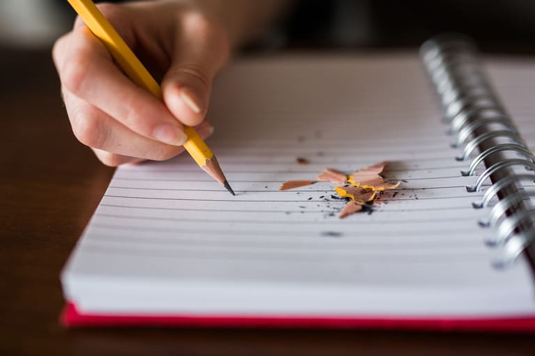 Onde escrever e aonde riscar o papel. Imagme destacada lápis no caderno