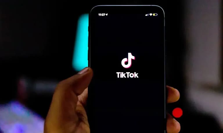 Pessoa segura celular com a tela inicial do TikTok aberta