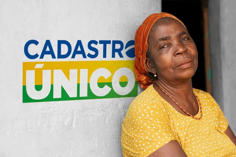 Mulher usando blusa amarela junto a uma parede escrito "Cadastro único"