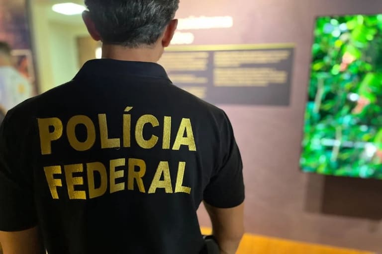 Polícia Federal: Agente da PF com camisa de identificação em ambiente institucional
