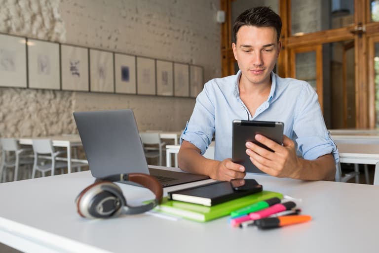 Jovem estudando em tablet, usando aplicativos para aprender matemática de forma gratuita.
