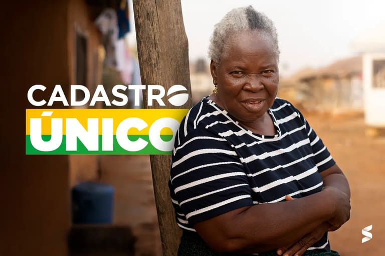 Uma mulher de mais idade em frente ao logo escrito "Cadastro Único".