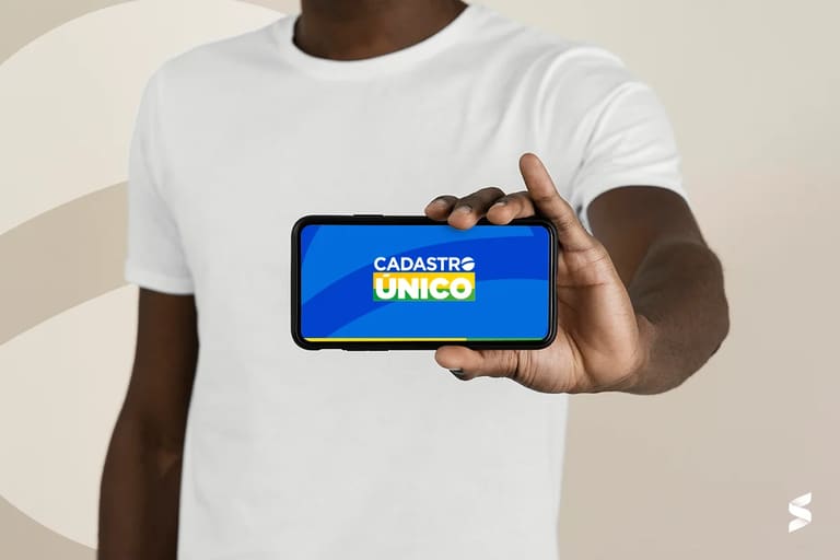 Pessoa segurando smartphone com a tela exibindo o logo do Cadastro Único, destacando a atualização digital.
