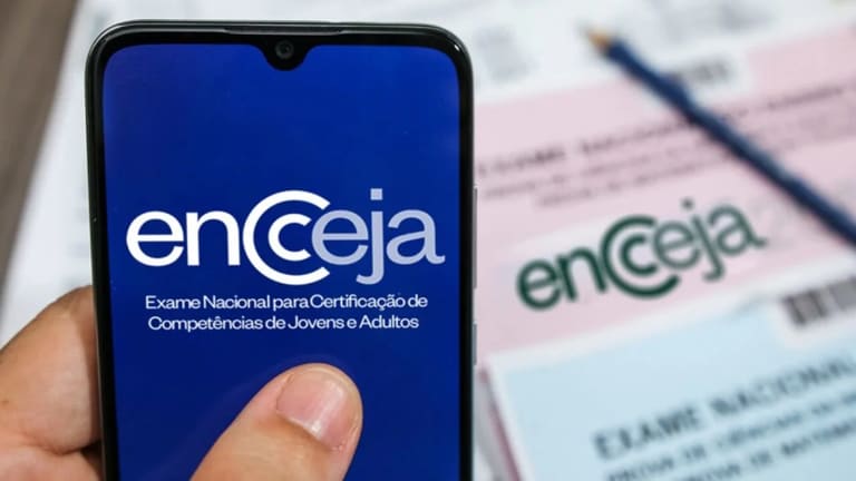 Tela de celular exibindo o logo do Encceja, com papel do exame ao fundo.