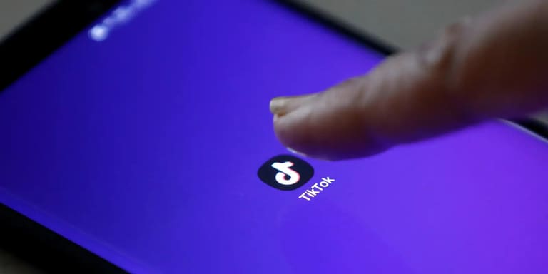 Pessoa acessando aplicativo do TikTok no celular.