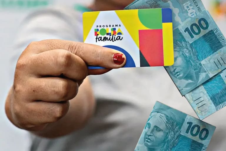 "Imagem do cartão Bolsa Família sendo segurado por uma mão, com cédulas de 100 Reais ao fundo, simbolizando o apoio financeiro."