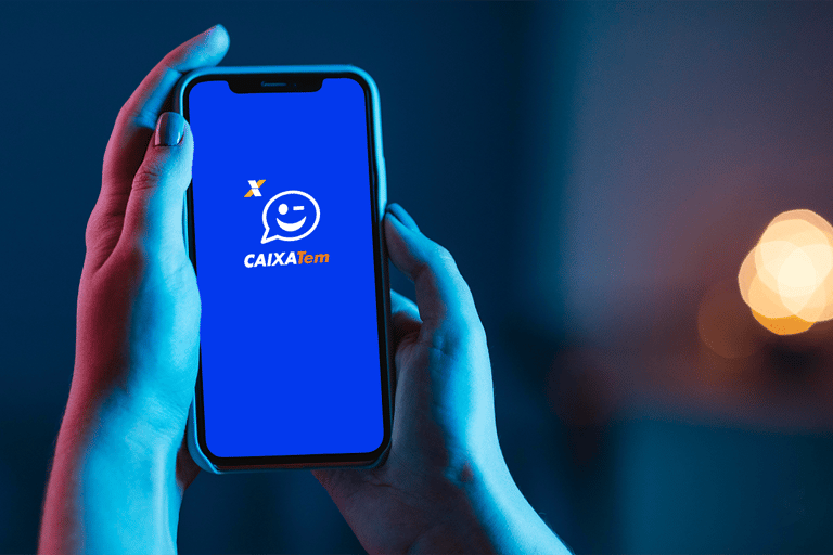 Pessoa segura celular com aplicativo Caixa Tem aberto na tela