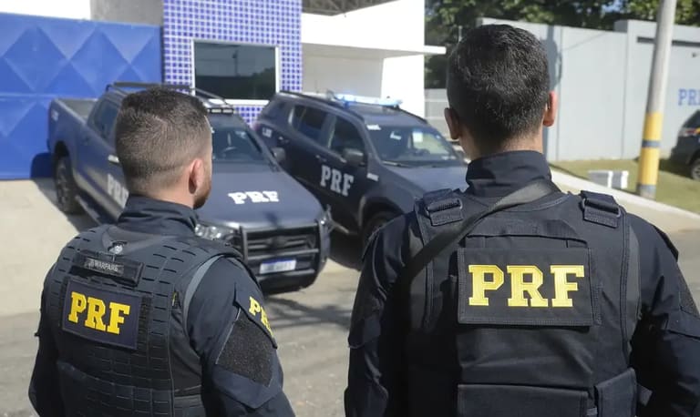 Policiais da PRF em frente a viaturas durante operação em unidade da corporação.