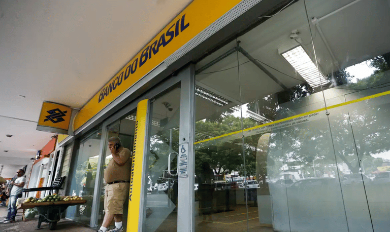 Fachada de agência do Banco do Brasil com movimento de clientes simbolizando oportunidades de carreira