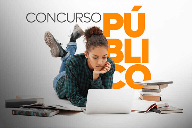 Estudante pesquisando no notebook com livros ao redor em preparação para concursos públicos