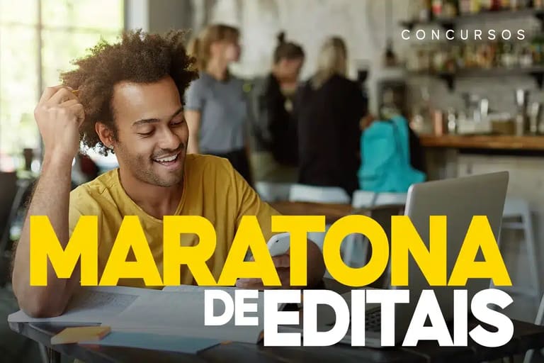 Homem sorridente estudando com laptop em café representando maratona de editais