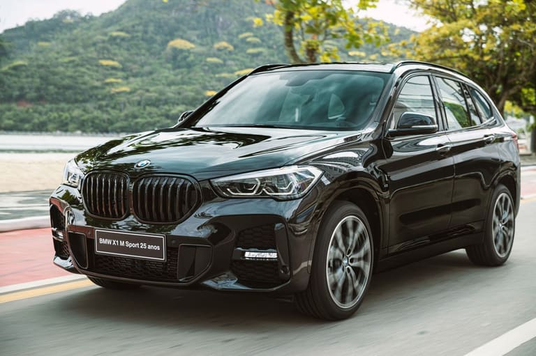 BMW X1 M Sport preto em movimento na beira-mar com grade frontal característica e design esportivo