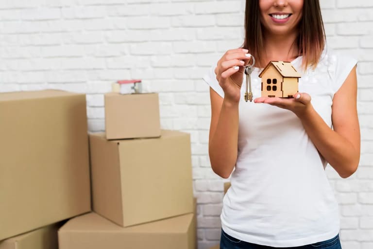Mulher segurando uma miniatura de casa e chaves, simbolizando novas regras de financiamento imobiliário.