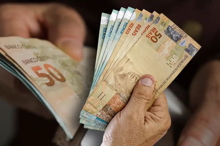 Cédulas representando o ajuste do salário mínimo 2026.