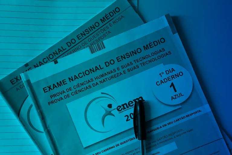 Cadernos do Exame Nacional do Ensino Médio ENEM com caneta sobre mesa azul