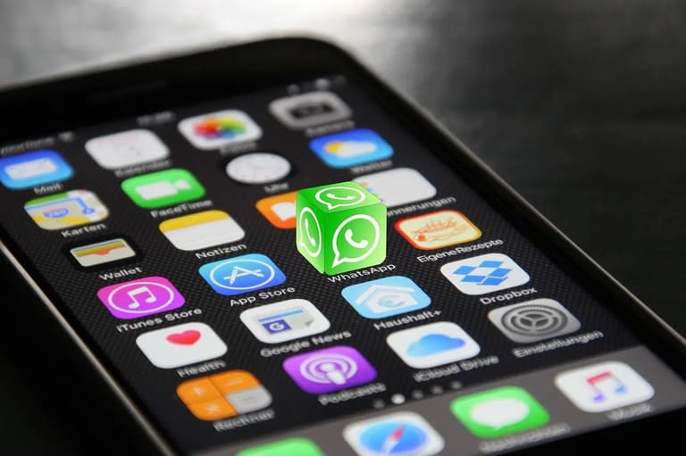 Ícone tridimensional do WhatsApp sobre a tela de um smartphone, ilustrando mudanças no uso de IA em aplicativos de mensagens em 2026.