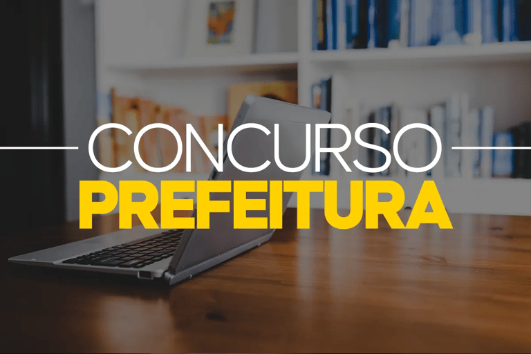 Notebook sobre mesa de madeira com estante de livros ao fundo representando o Concurso Prefeitura de Serraria PB oferece 131 vagas com salários até R$ 5.313.