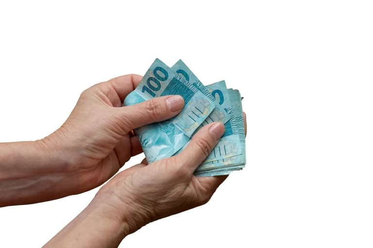 Mãos segurando notas de dinheiro, representando planejamento financeiro e aposentadoria para quem trabalha por conta própria