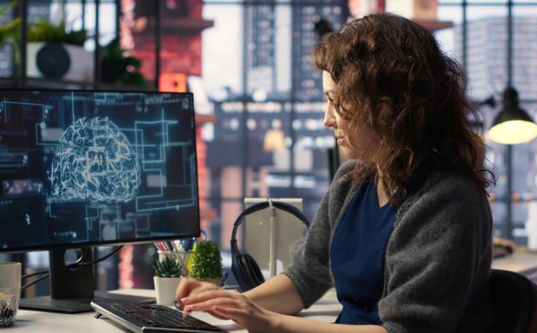 Profissional trabalhando em computador com visualização de cérebro digital e inteligência artificial na tela.
