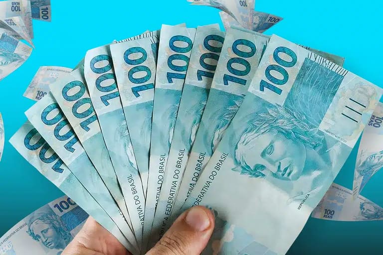 Dinheiro em notas de cem reais representando salário de janeiro pago sem desconto de imposto para trabalhadores