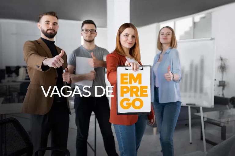 Quatro pessoas de negócios mostrando o sinal de positivo e segurando um cartaz de vagas de emprego em um ambiente de escritório moderno.