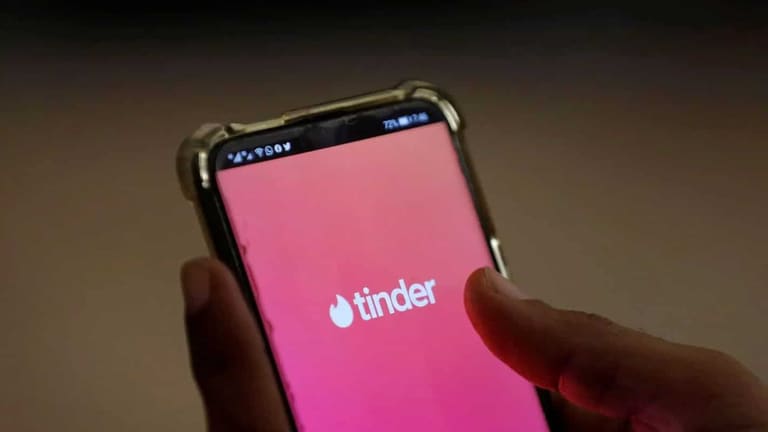 Tela inicial do aplicativo Tinder com o logo visível, destacando a interface com novos recursos de astrologia e química para encontrar o match ideal.