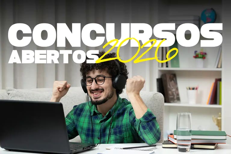 Concursos de Prefeituras 2026 Homem sorrindo com fones de ouvido, vibrando em frente ao notebook, rodeado de livros