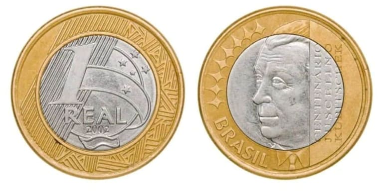 Lado a lado, as duas faces da moeda de 1 real de 2002. À esquerda, o valor de face com a data. À direita, o busto de Juscelino Kubitschek com a inscrição Centenário Juscelino Kubitschek.