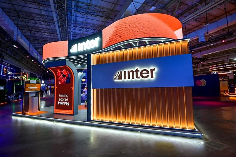 Stand institucional do Banco Inter em evento com logotipo iluminado representando a oferta de 98% de desconto na renegociação de dívidas