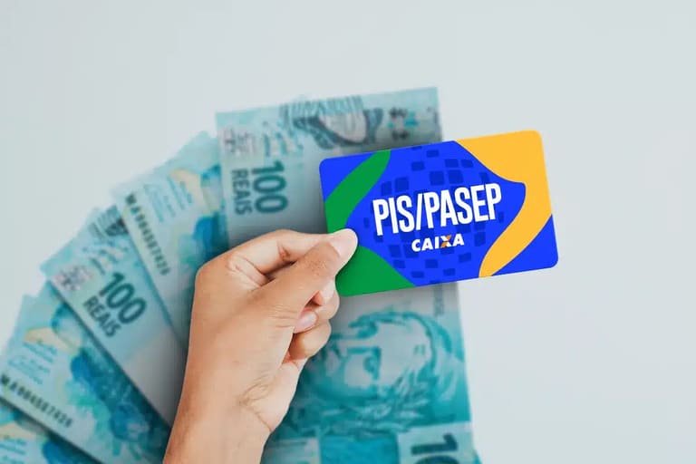 Cartão PIS/PASEP da Caixa sobre notas de R$ 100,00.