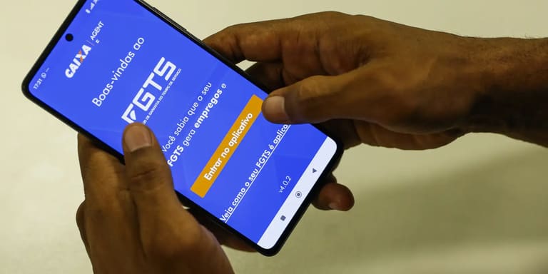 Trabalhador acessando o aplicativo da Caixa para consultar o FGTS, com foco na possível liberação de R$ 17 bilhões para ajudar trabalhadores endividados.