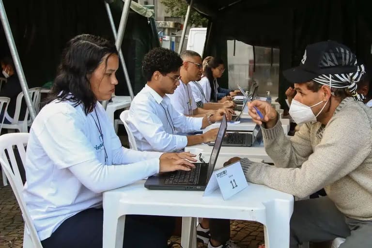 Profissional atendendo cidadão para emissão de documentos, representando o serviço prestado durante o mutirão de registro civil.