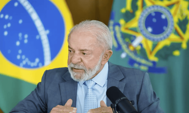 Presidente Lula durante pronunciamento oficial com bandeiras do Brasil ao fundo sobre proposta de fim da escala 6x1
