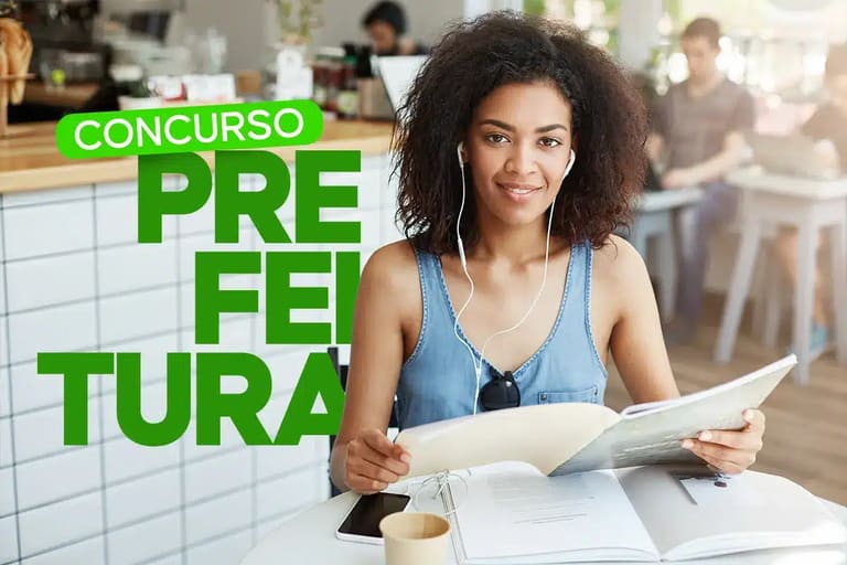 Concurso Prefeitura de Inimutaba MG 2026 - jovem estudando com fone de ouvido e livros abertos