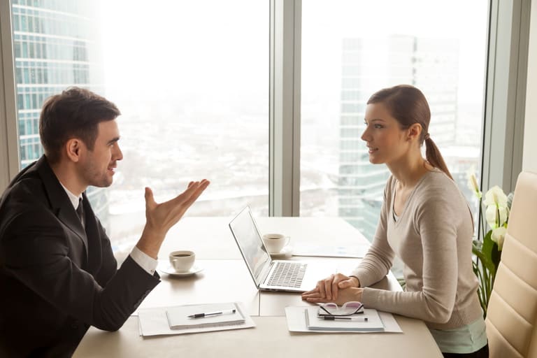 Funcionário apresentando resultados ao gestor em reunião de negociação salarial