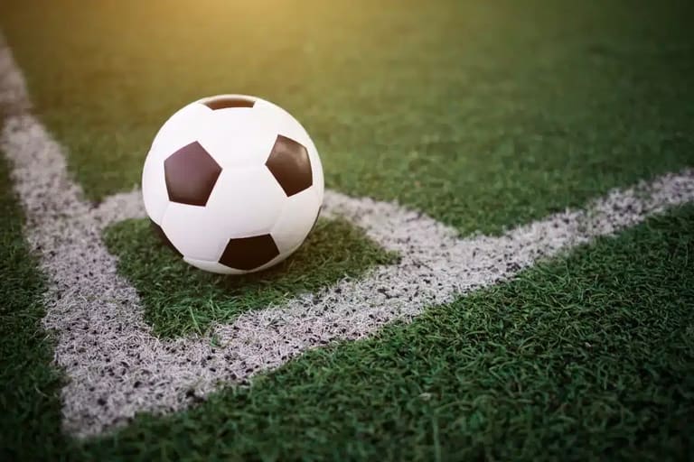 Bola de futebol em campo, próxima à linha de marcação, representando as várias oportunidades de atuação no futebol além dos jogadores.