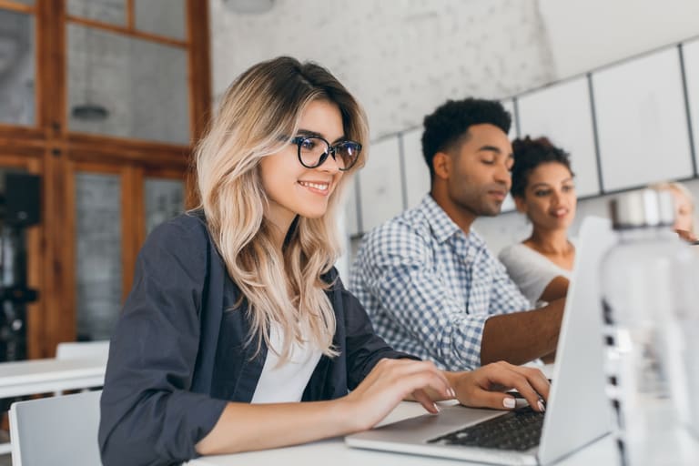 Jovens estagiários trabalhando em notebook no escritório — estagiários podem ganhar salário mínimo com novo projeto de lei 2026