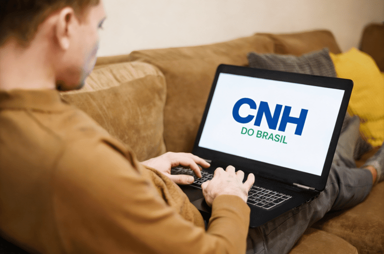 Homem acessa plataforma CNH do Brasil em notebook no sofá.