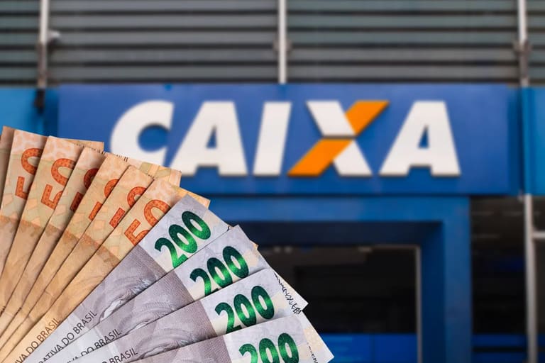 Notas de reais em frente a uma agência da Caixa, representando saque de R$ 6.220 disponível para solicitação.