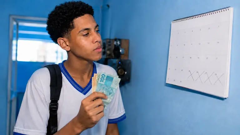 Estudante brasileiro conferindo o calendário e segurando dinheiro, ilustrando o depósito do benefício Pé-de-Meia em junho.